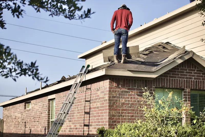 Professional roofer working on a residential roof in Naranja